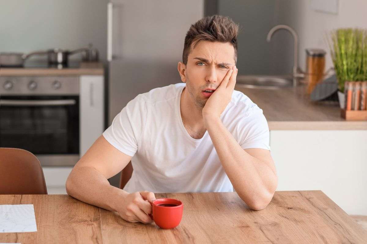 Ragazzo assonnato beve caffè